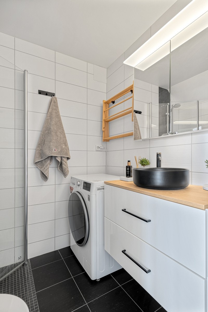 Badet har bl.a. servant med skuffer og tilhørende speilskap, opplegg til vaskemaskin og vegghengt toalett. Galleribilde