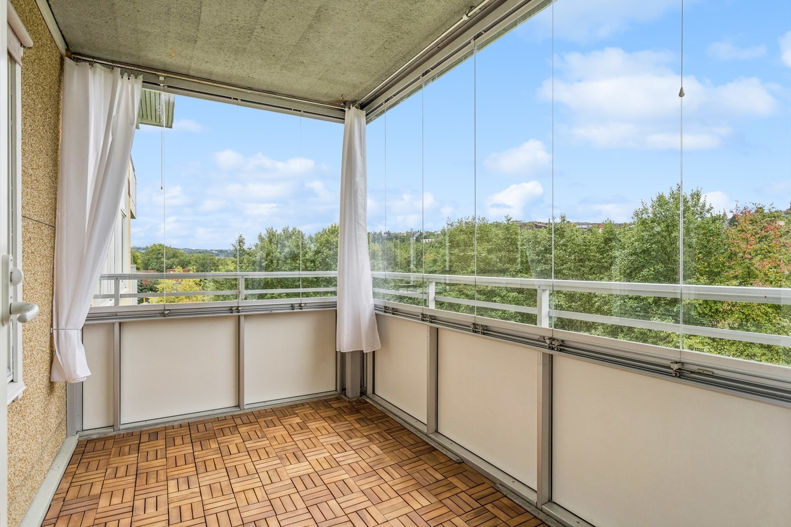 Den innglassede balkongen er ca 7,2 m² og har varme i gulv i følge selger. Glassvinduene kan åpnes og skyves til siden. Galleribilde