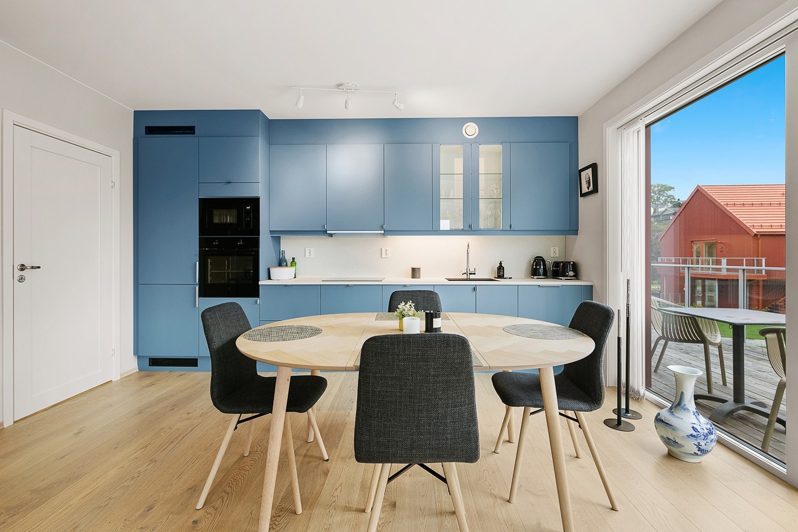 Kjøkkenet har innredning fra Norema i en moderne farge med slette fronter og integrerte hvitevarer Galleribilde