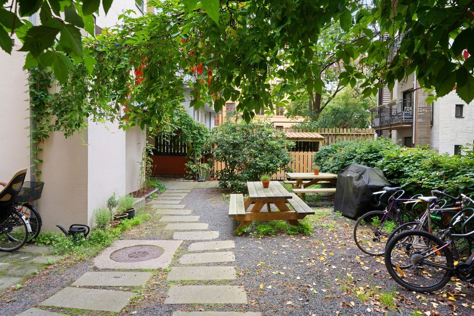 Leiligheten har et skjermet og hyggelig fellesområde med benker, grill og sykkelparkering Galleribilde