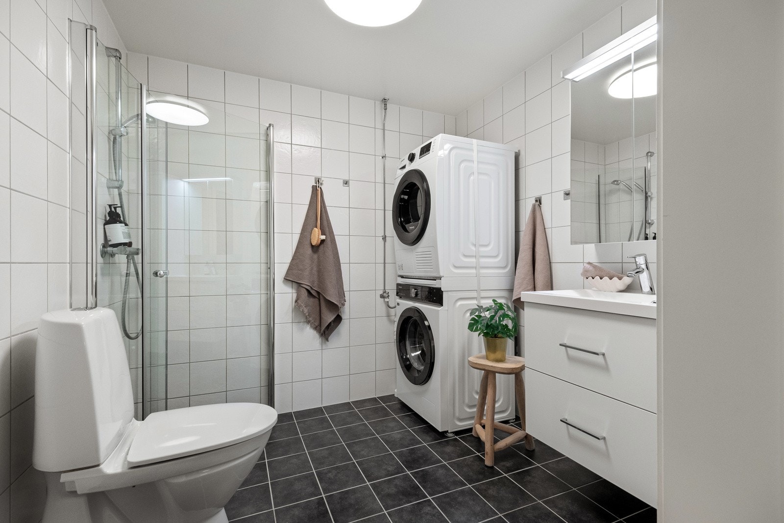 Badet er innredet med dusjhjørne, servant med underskap, speilskap over vask og toalett. Galleribilde