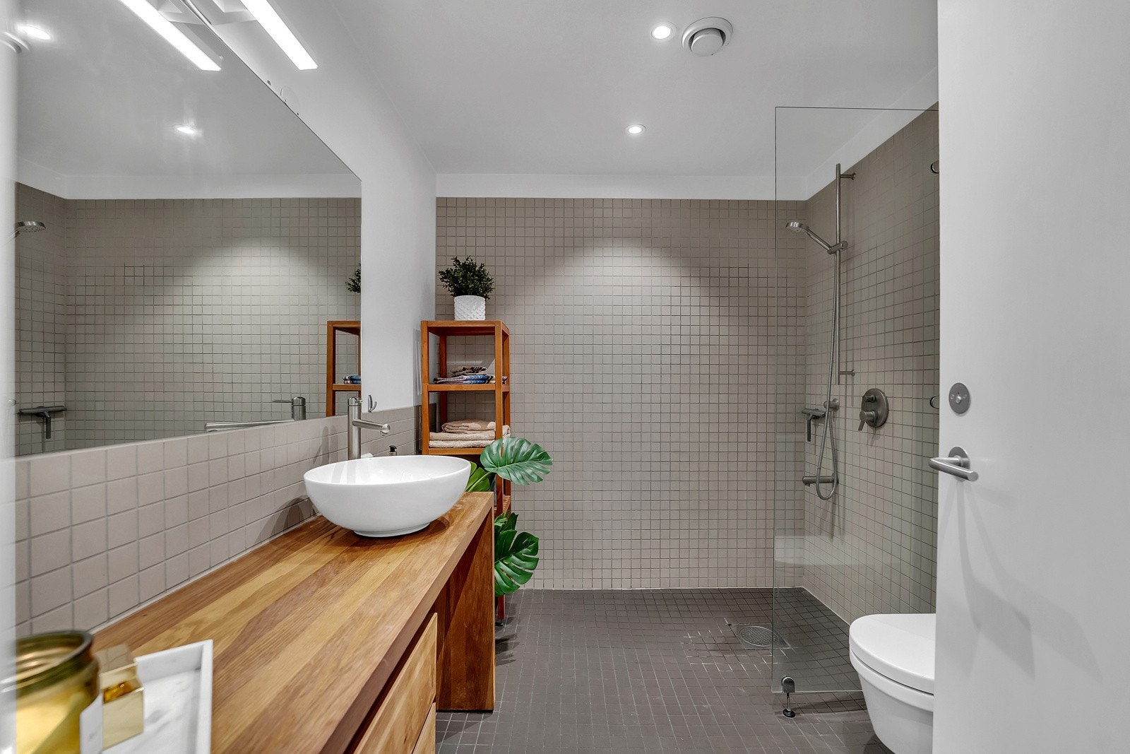 Delikat, flislagt baderom med "alt" et fullverdig baderom skal inneholde. Her får du både dusjnisje, opplegg til vaskemaskin, klosett, benkeplass og servantbolle. Det er downlights i himling på badet. Galleribilde