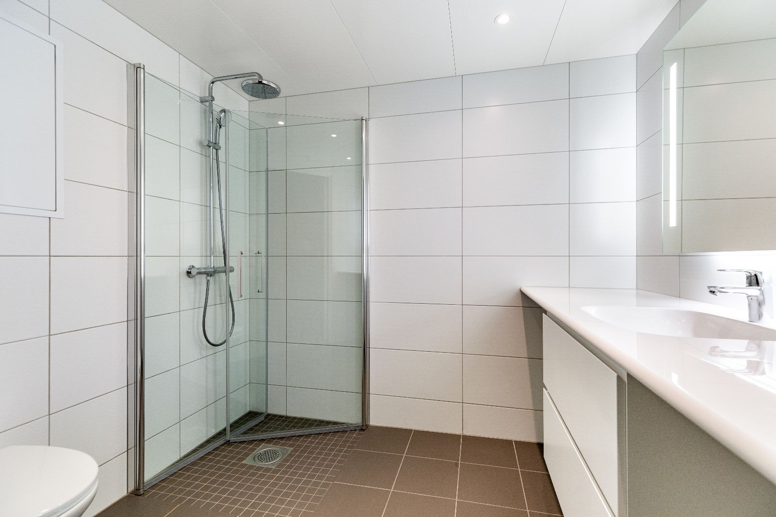 Pent flislagt bad med varmekabler og opplegg for vaskemaskin. Galleribilde