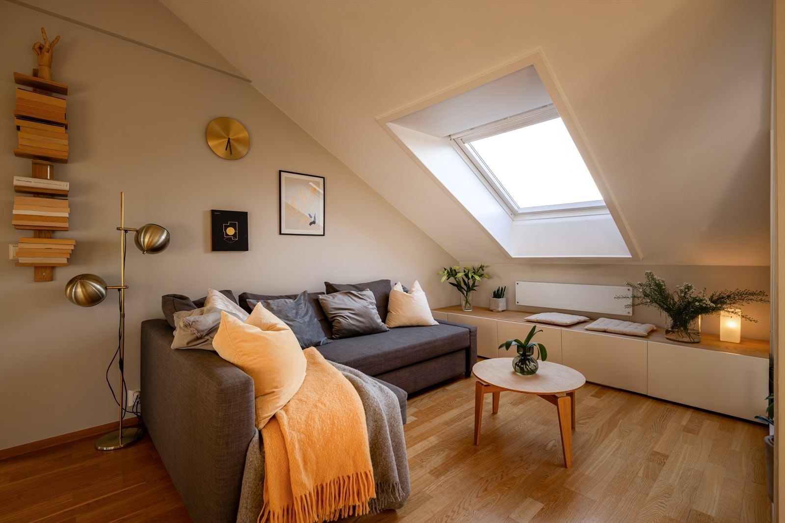 Leiligheten har en nydelig stue med generøs takhøyde! Stuen er innbydende med parkett på gulvet og Velux takvindu som slipper inn rikelig med naturlig lys. Rommet er malt i lyse farger og har smart skapoppbevaring plassert under vindu, langs veggen. Galleribilde