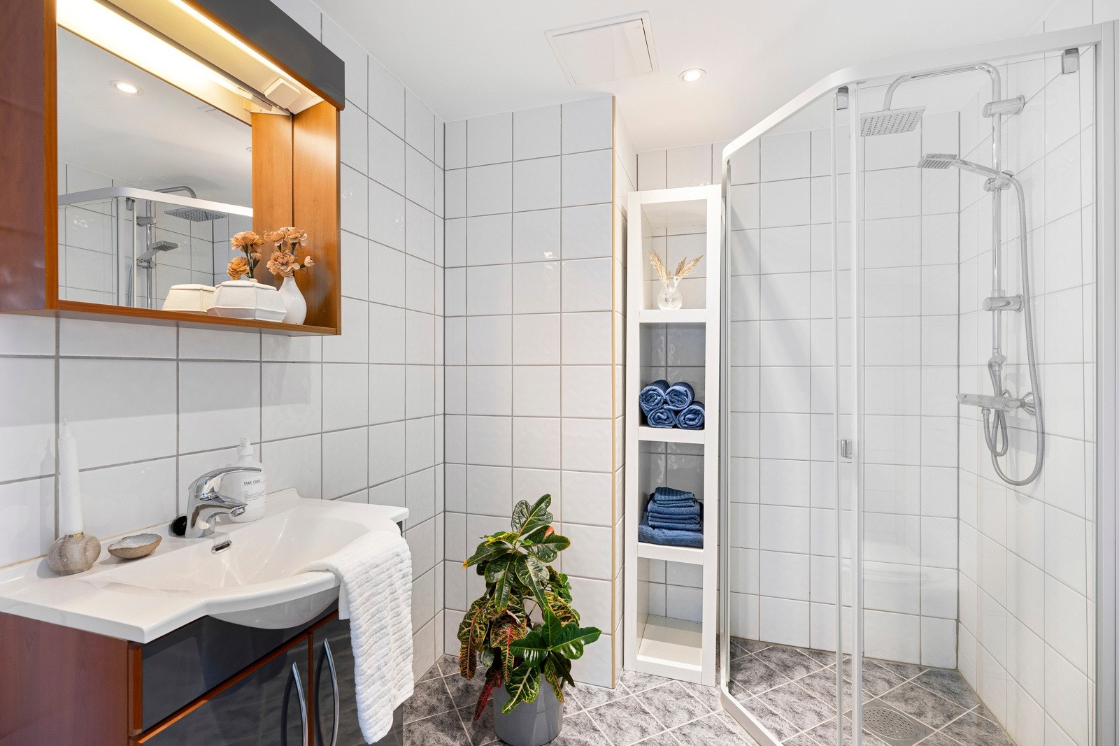 Badet byr på fliser på både vegger og gulv, noe som gir en helhetlig og lettstelt overflate. Galleribilde