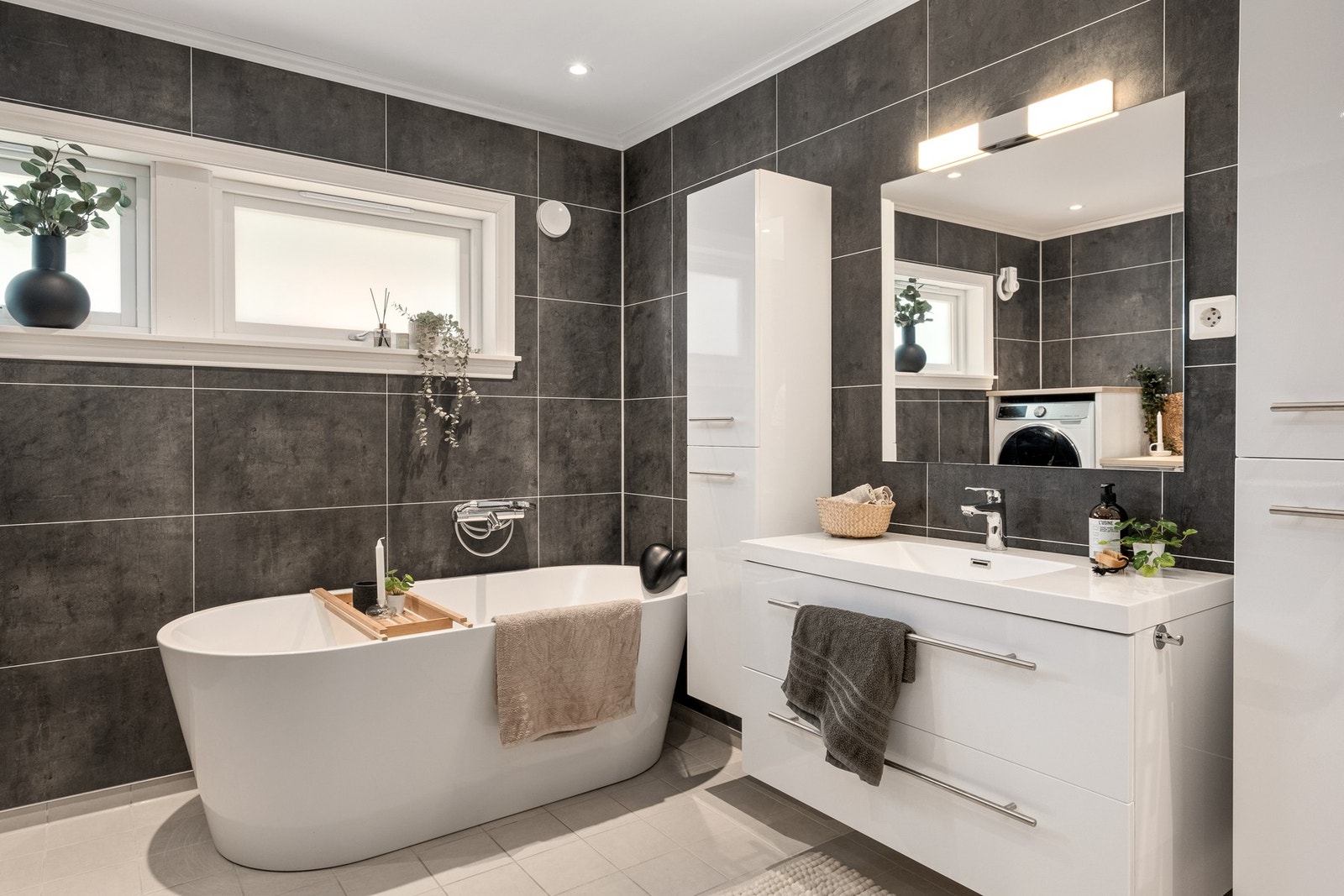 ...servant m/speil og belysning, vegghengt toalett, opplegg for vaskemaskin, og laminat benkeplate. Galleribilde