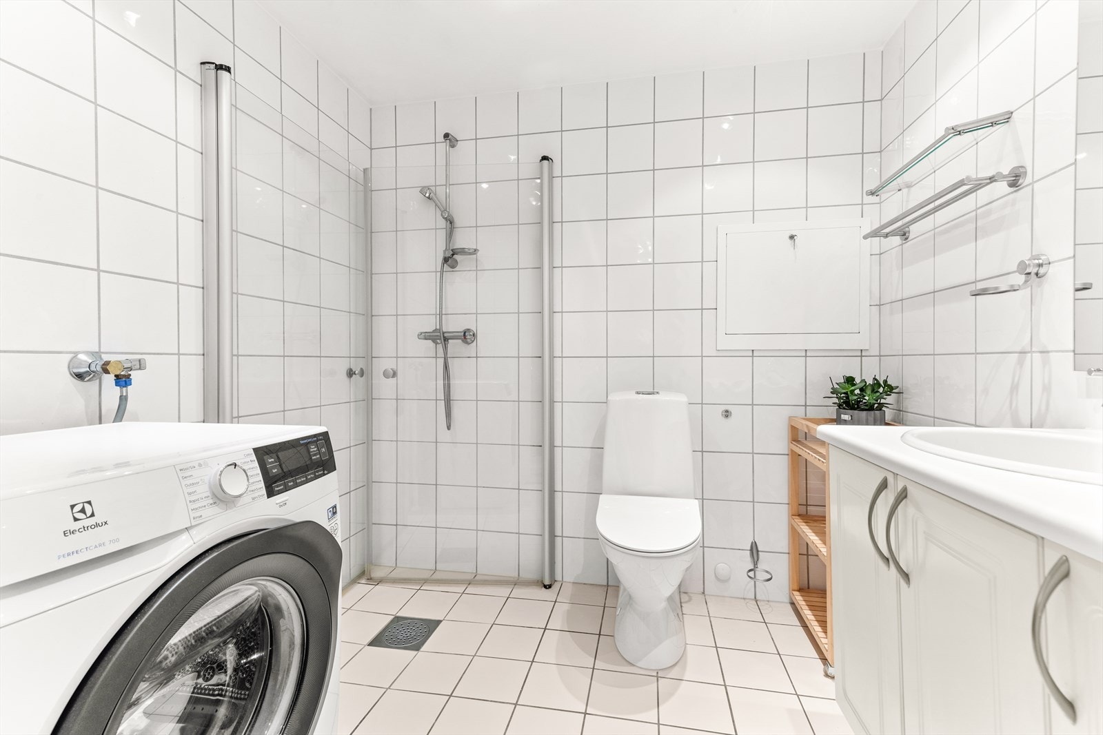 Flislagt bad med underliggende varme i gulv. Badet er videre utstyrt med servant, servanmøblement, dusj m/innfellbare glassdører, gulvstående toalett og opplegg for vaskemaskin/tørketrommel Galleribilde
