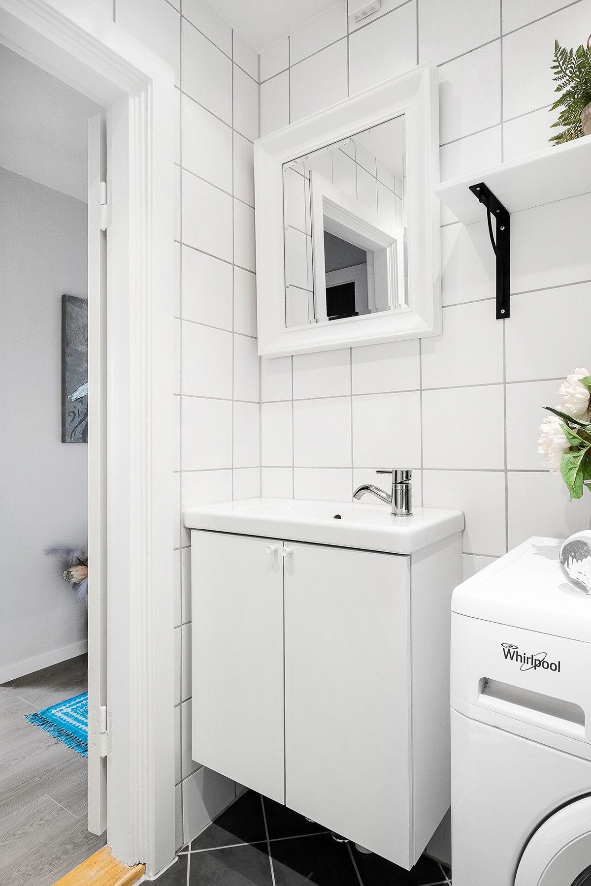 Bad består av åpen dusj på gulv med forheng, gulvmontert wc og servant. Opplegg for vaskemaskin Galleribilde