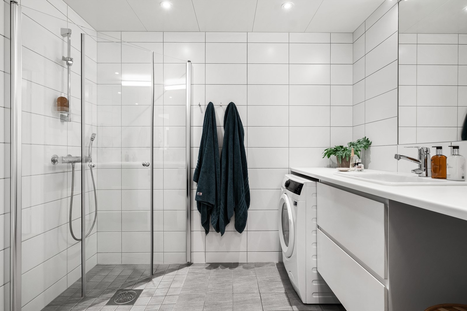 Innredet med vegghengt klosett, servant med innredning, innfelt speil og dusjhjørne med svingbare glassdører. Opplegg for vaskemaskin. Balansert ventilasjon. Kombimaskin (vask/tørk) medfølger handelen. Galleribilde