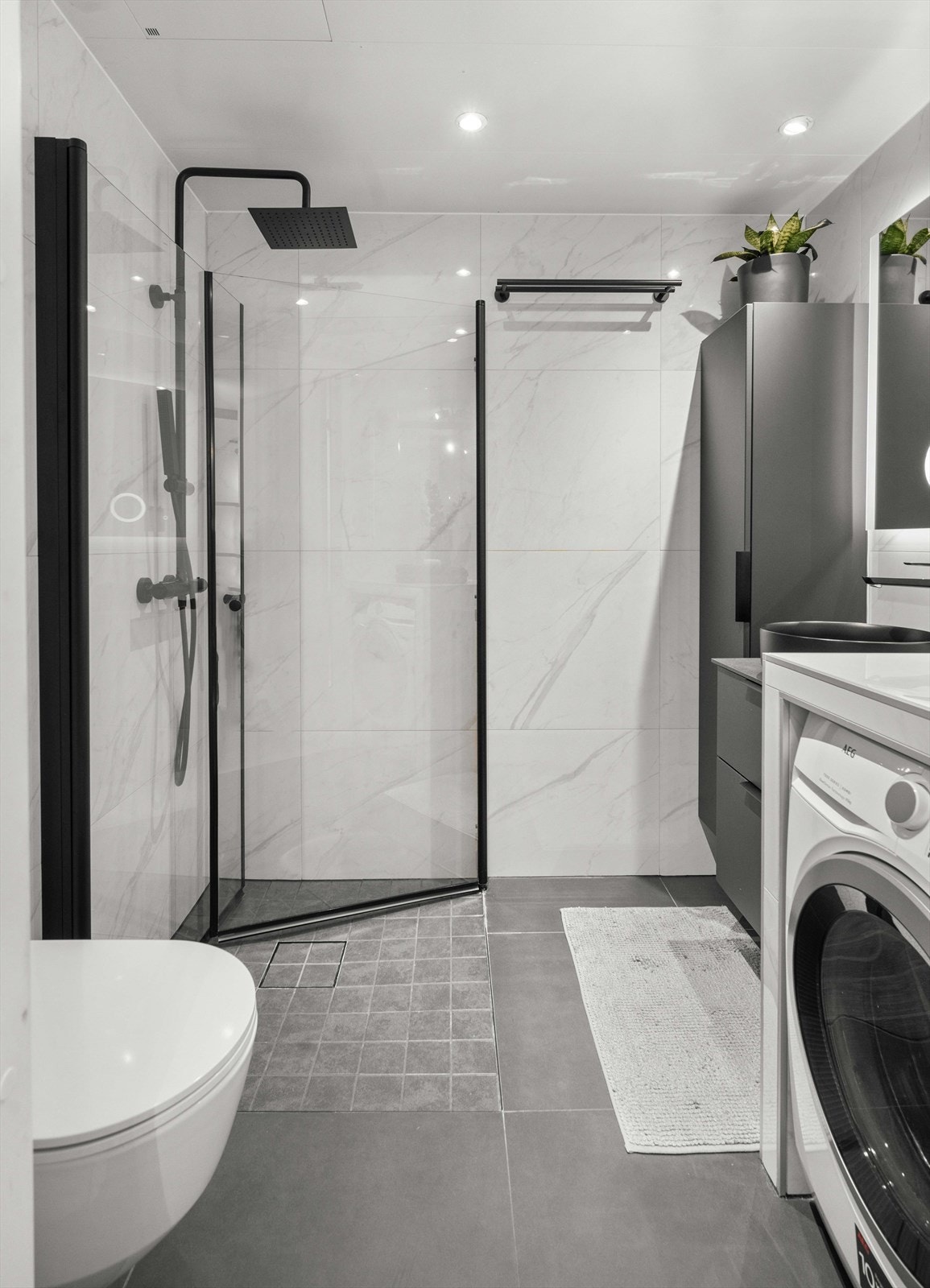 Badet er flislagt med varme i gulv og downlights i himling Galleribilde