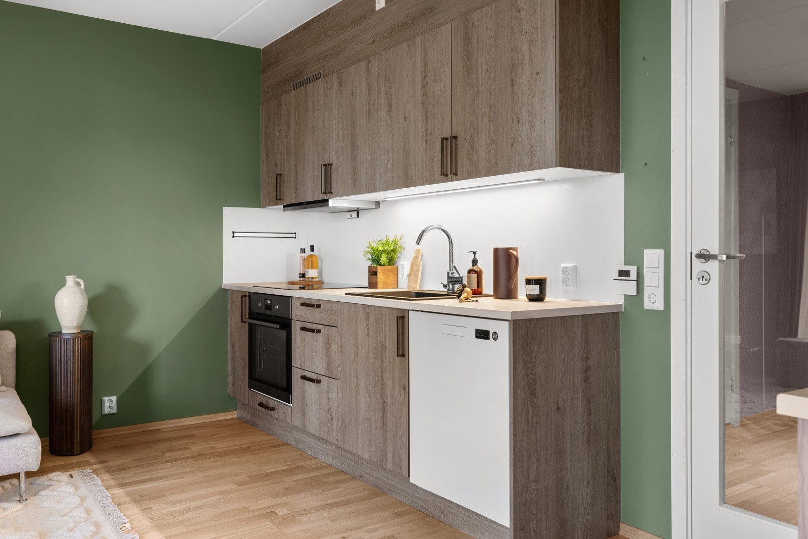 Pent kjøkken med integrerte hvitevarer og god skap- og benkeplass Galleribilde