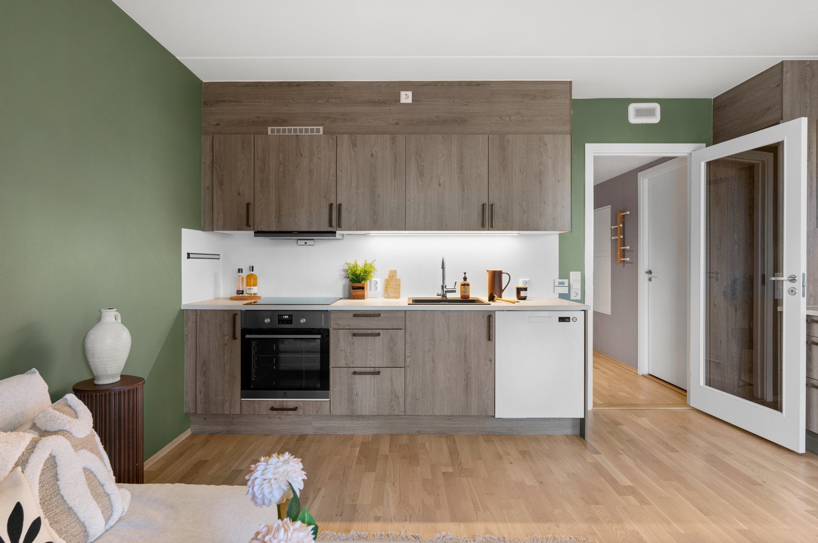 Pent kjøkken med integrerte hvitevarer og god skap- og benkeplass Galleribilde