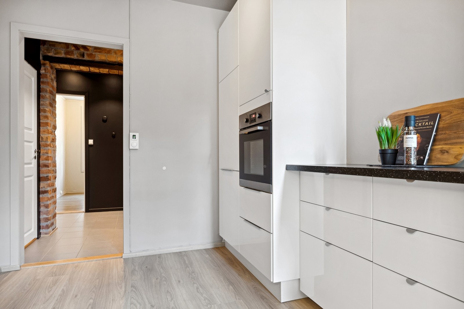 Kjøkkeninnredning fra Ikea med benkeplate i laminat og fliser mellom kjøkkenbenk og overskap. Galleribilde