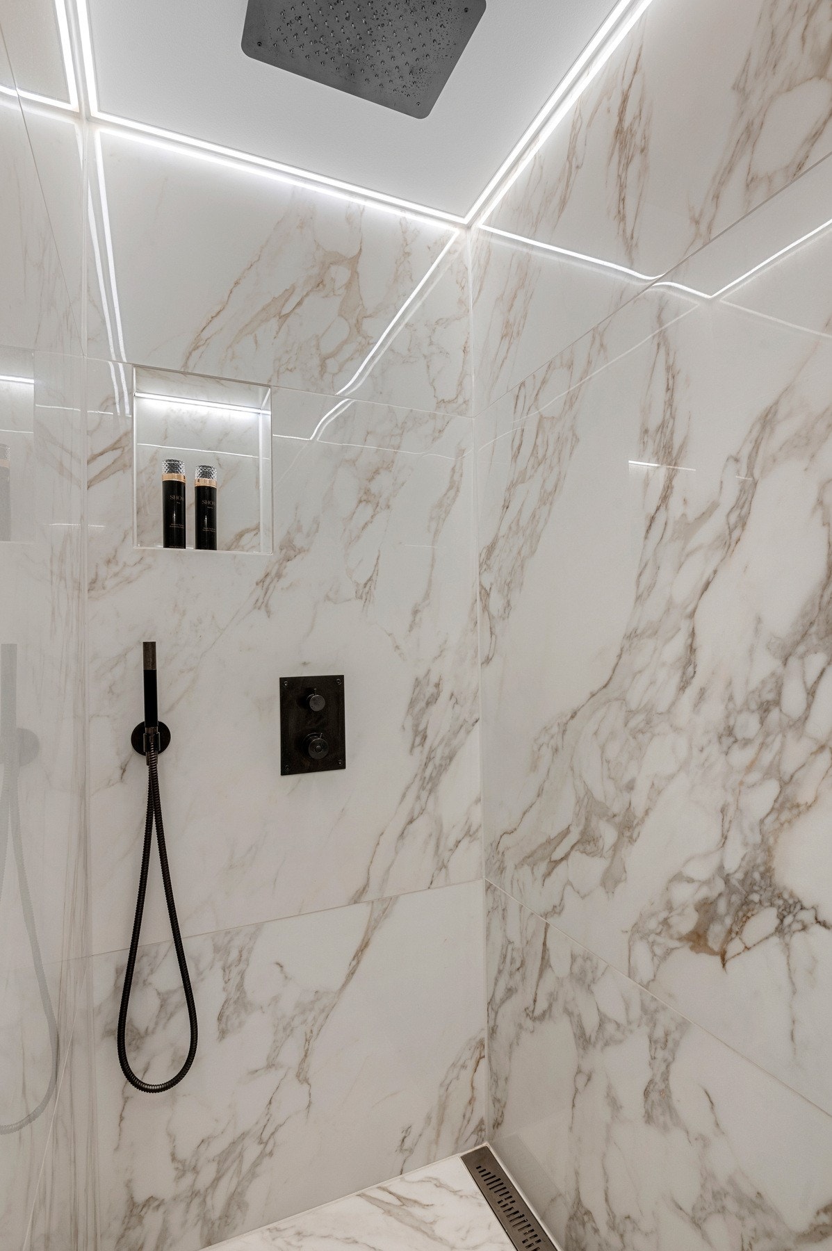 Egen dusjnisje med integrerte armaturer og regndusj. Legg merke til detaljene for både oppbevaring og belysning. Galleribilde