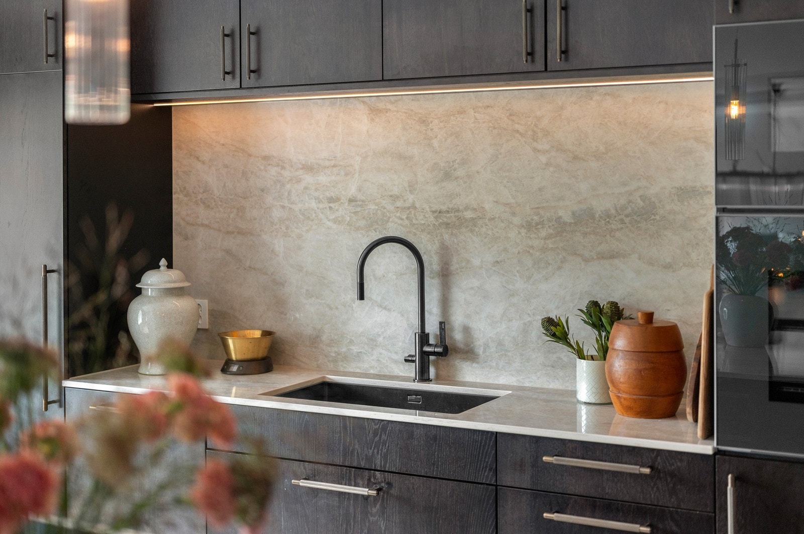 Servanten er er flott omrammet av kjøkkeninnredningen. På venstre side er det langskap for både fryser og kjøleskap. Galleribilde