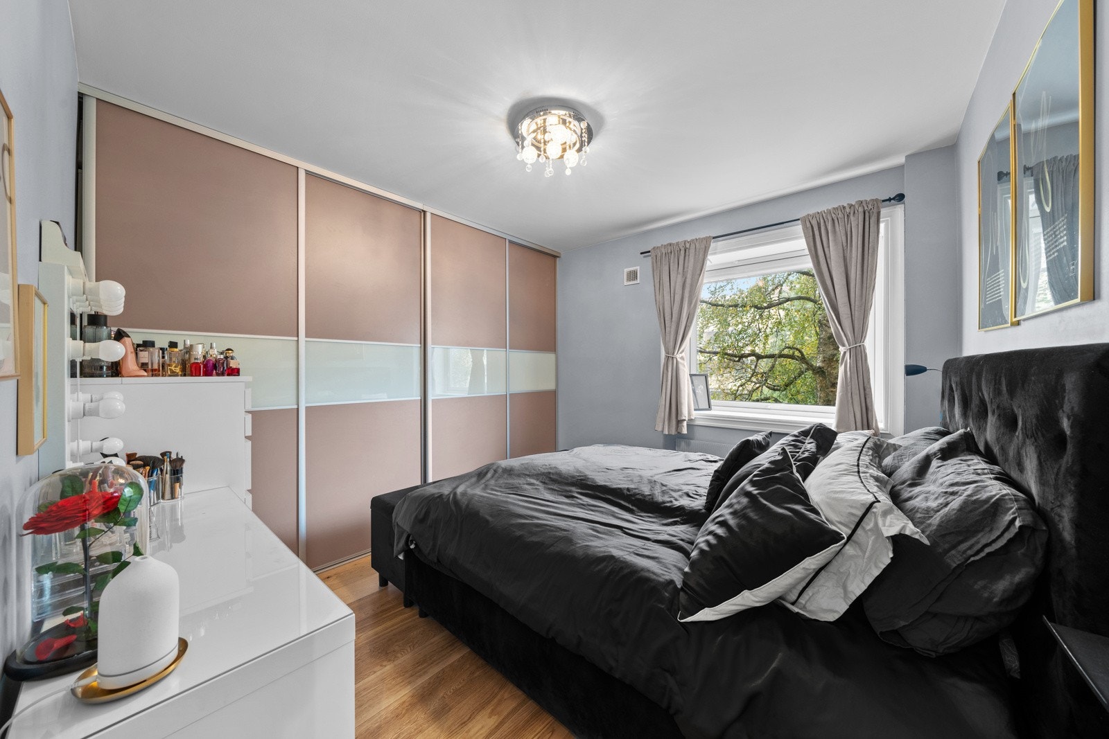 Lyst og romslig soverom med store vinduer, nøytrale vegger og plassbygd garderobe som tilbyr rikelig med lagringsplass. Galleribilde