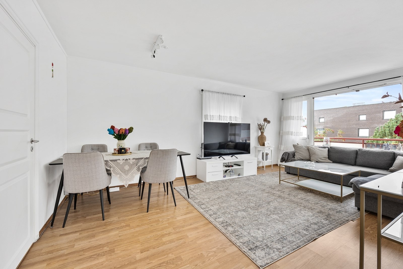 Lys og luftig oppholdsrom med spisesone, stue og utgang til balkong. Galleribilde