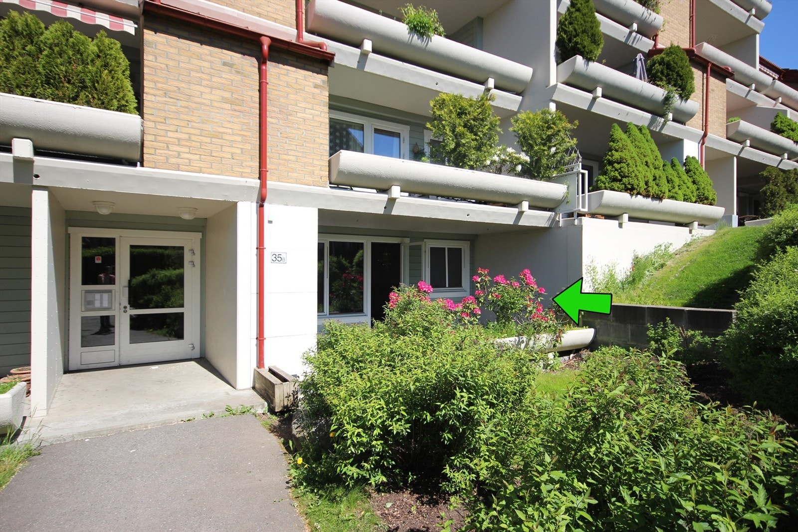 Fasade inngang - pilen viser leilighetens markterrasse. Galleribilde