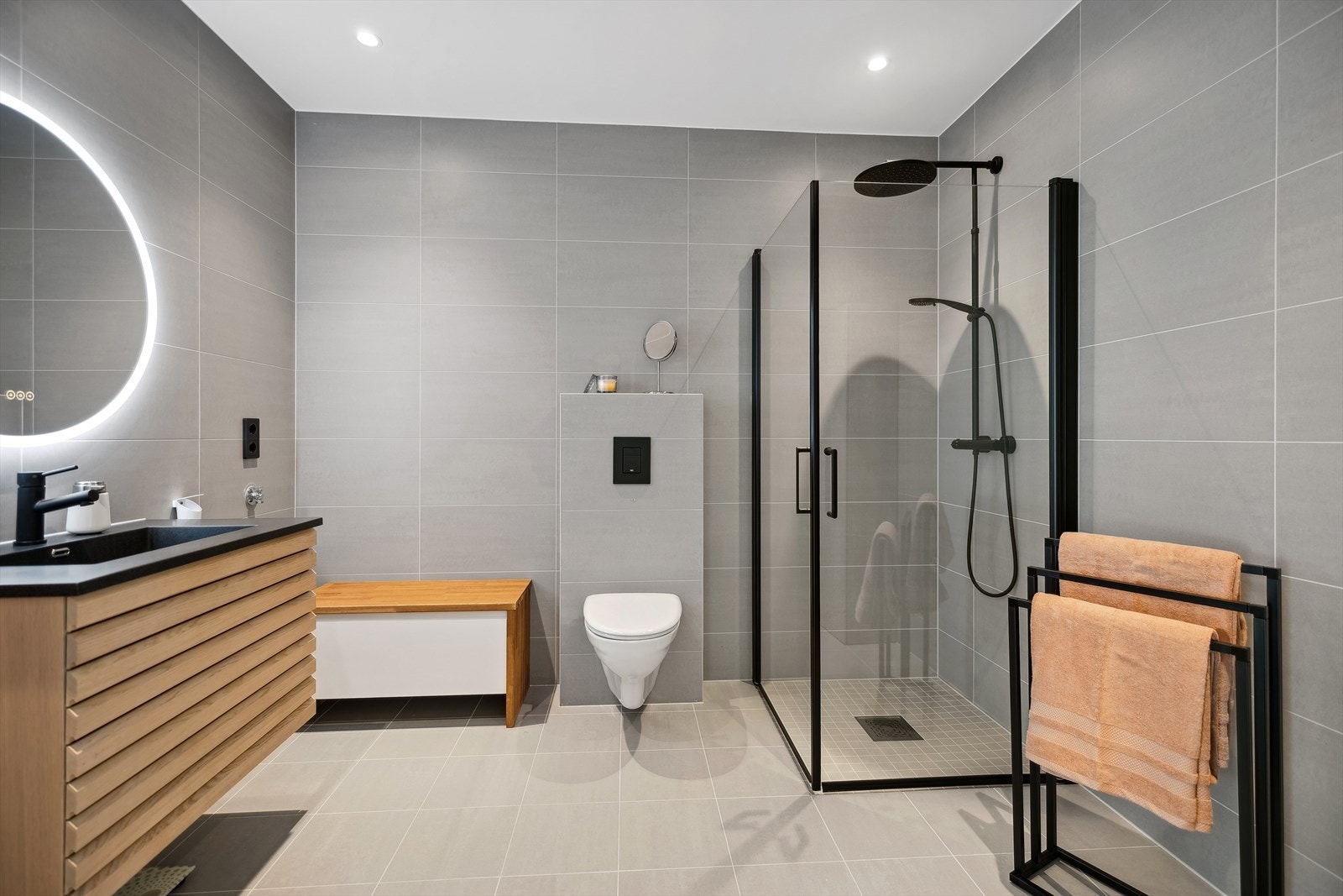 Badet er innredet med servantskap med ett-greps blandebatteri, vegghengt toalett med innebygget sisterne, høyskap, speil med lys, avskjermet dusjhjørne med glass, blandebatteri og dusjgarnityr. Det er opplegg for vaskemaskin. Galleribilde