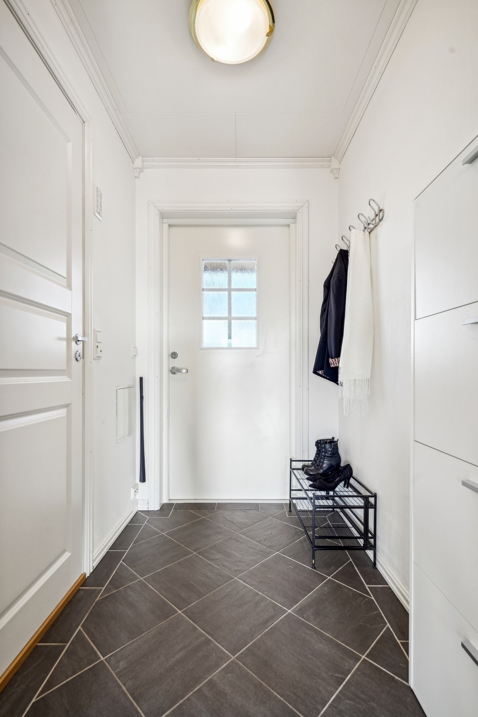 Entréen er lys og fin og med pene detaljer på flisleggingen Galleribilde