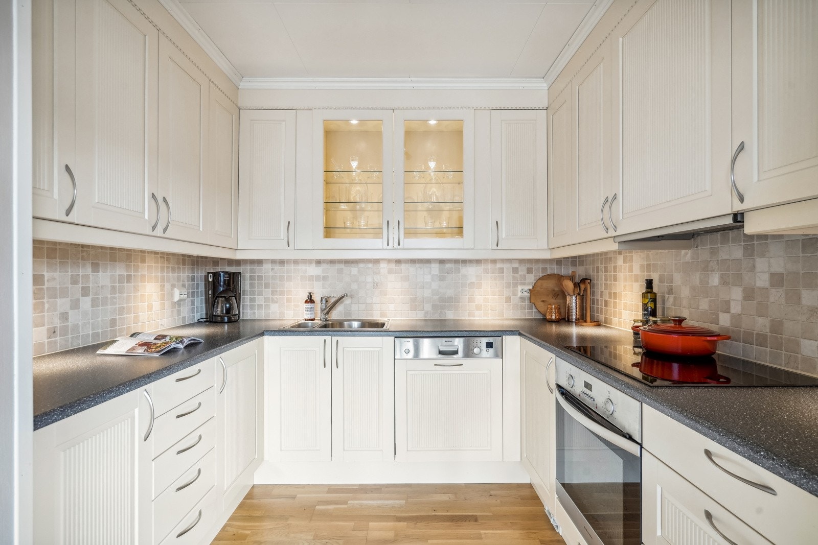 Her finnes praktisk arbeidsplass, ventilator har avtrekk ut og det er fliser mellom benkeplate og overskap Galleribilde