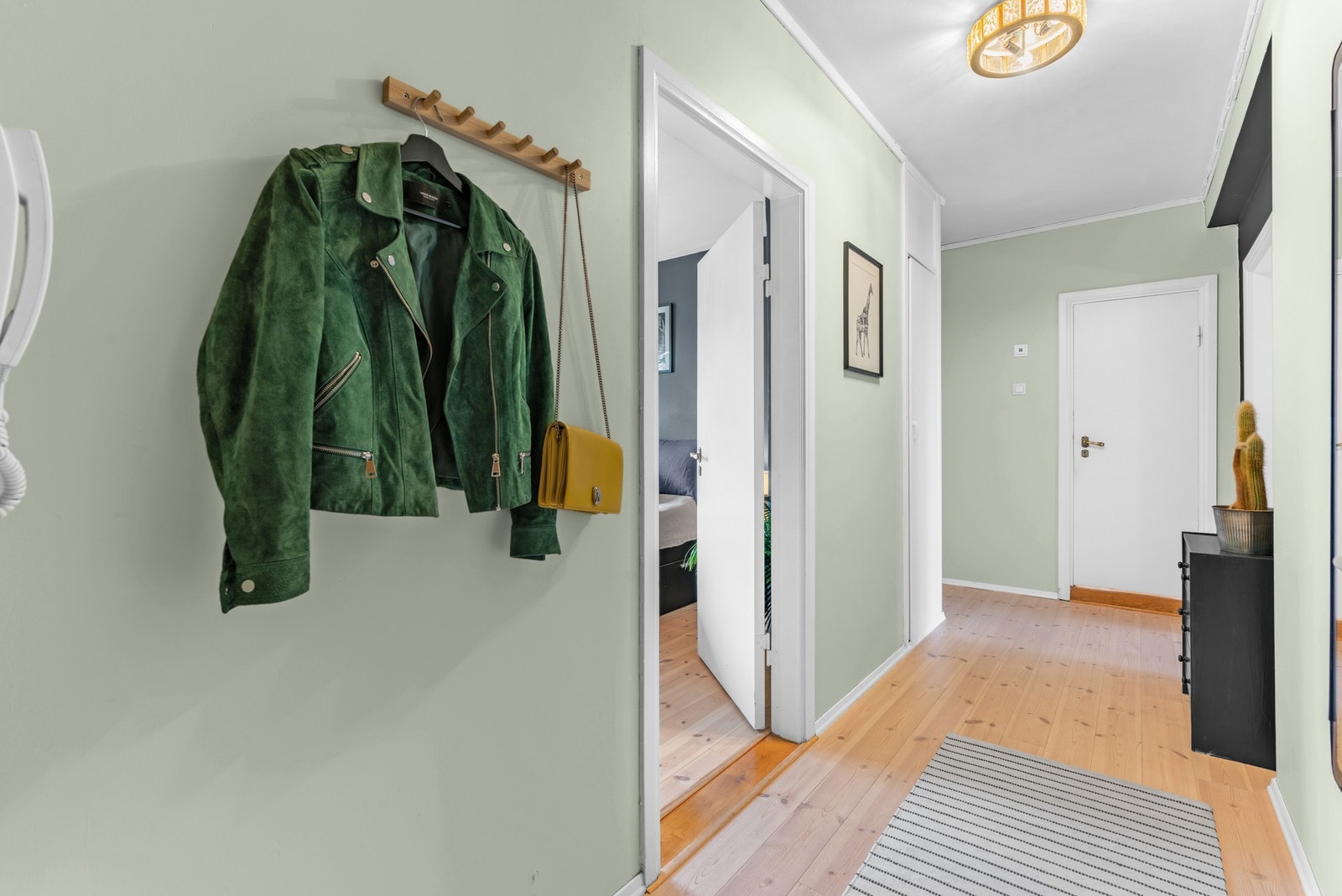 Her kommer du inn til en innbydende og romslig entré med heltre furugulv og malte, glatte flater på vegg Galleribilde