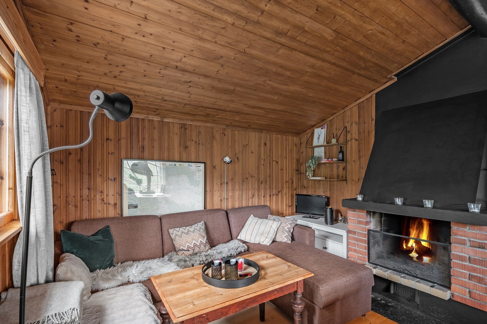 Koselig sofakrok med peis, puter og pledd. Perfekt for avslapning Galleribilde