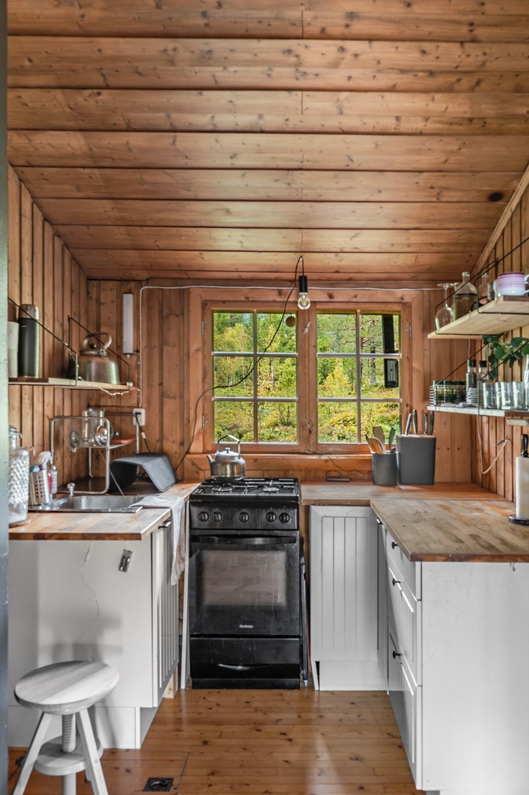 Innredningen består av underskap, hyller i heltre, benkeplate i heltre og en oppvaskkum i rustfritt stål, som gir en rustikk og varm følelse. Galleribilde