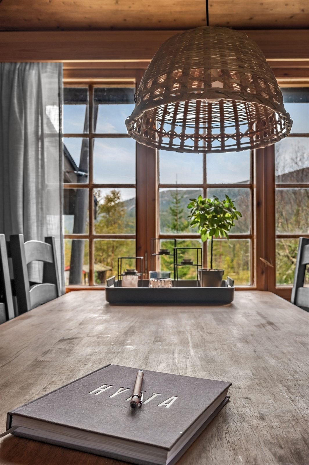 Et stort vindu slipper inn rikelig med naturlig lys, som sammen med den åpne peisen, gjør stua til et lyst og trivelig oppholdsrom. Galleribilde