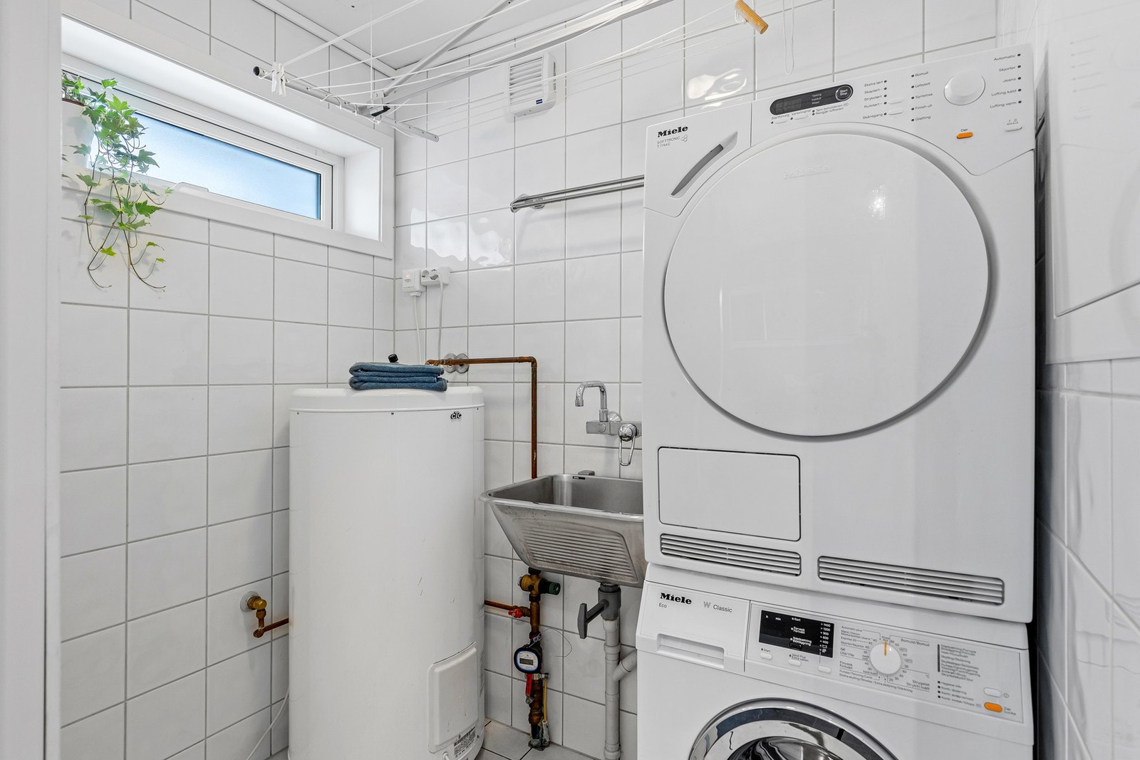 Boligen har også et eget vaskerom med opplegg for vaskemaskin, tørketrommel og utslagsvask. Galleribilde