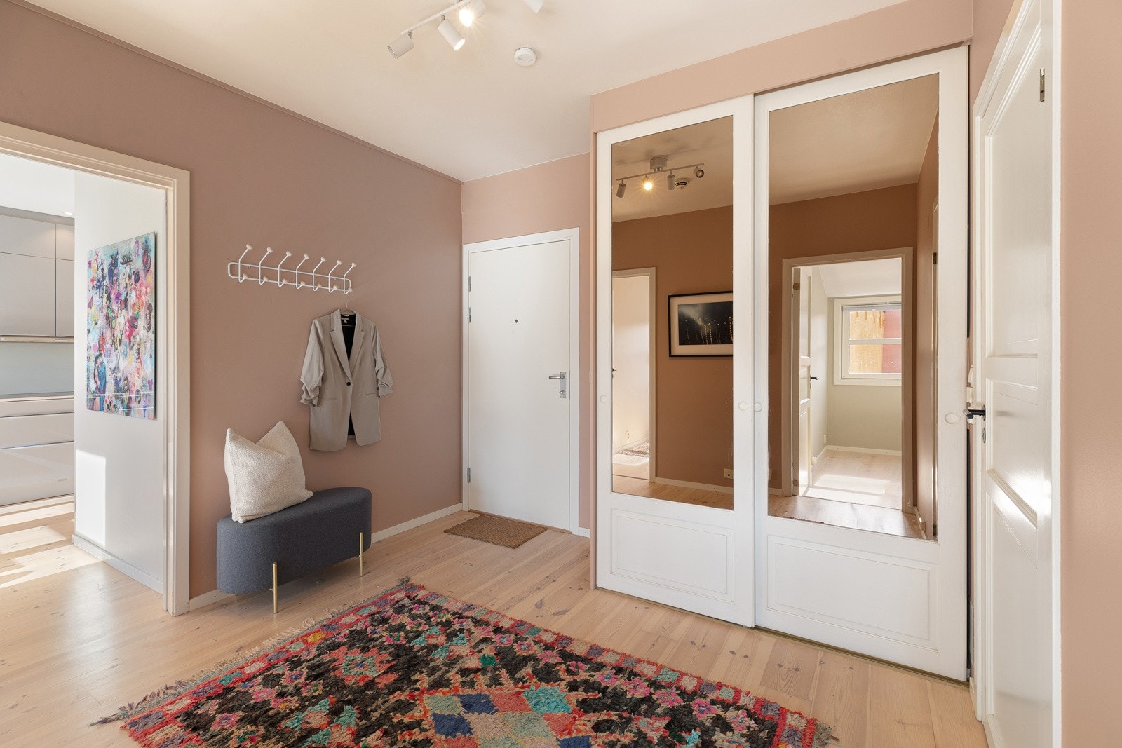 Romslig og innbydende entrè med praktisk garderobeskap og ekstra oppheng for yttertøy Galleribilde