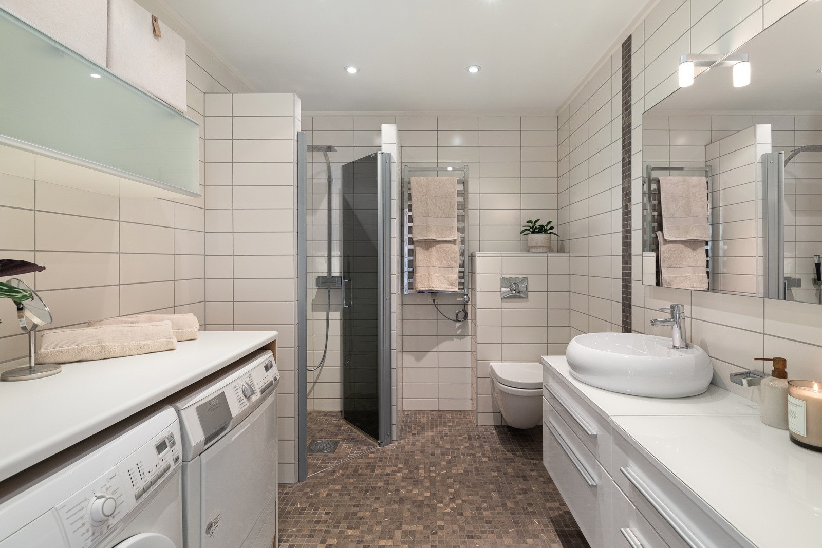 Arealeffektivt og pent flislagt baderom med varmekabler Galleribilde