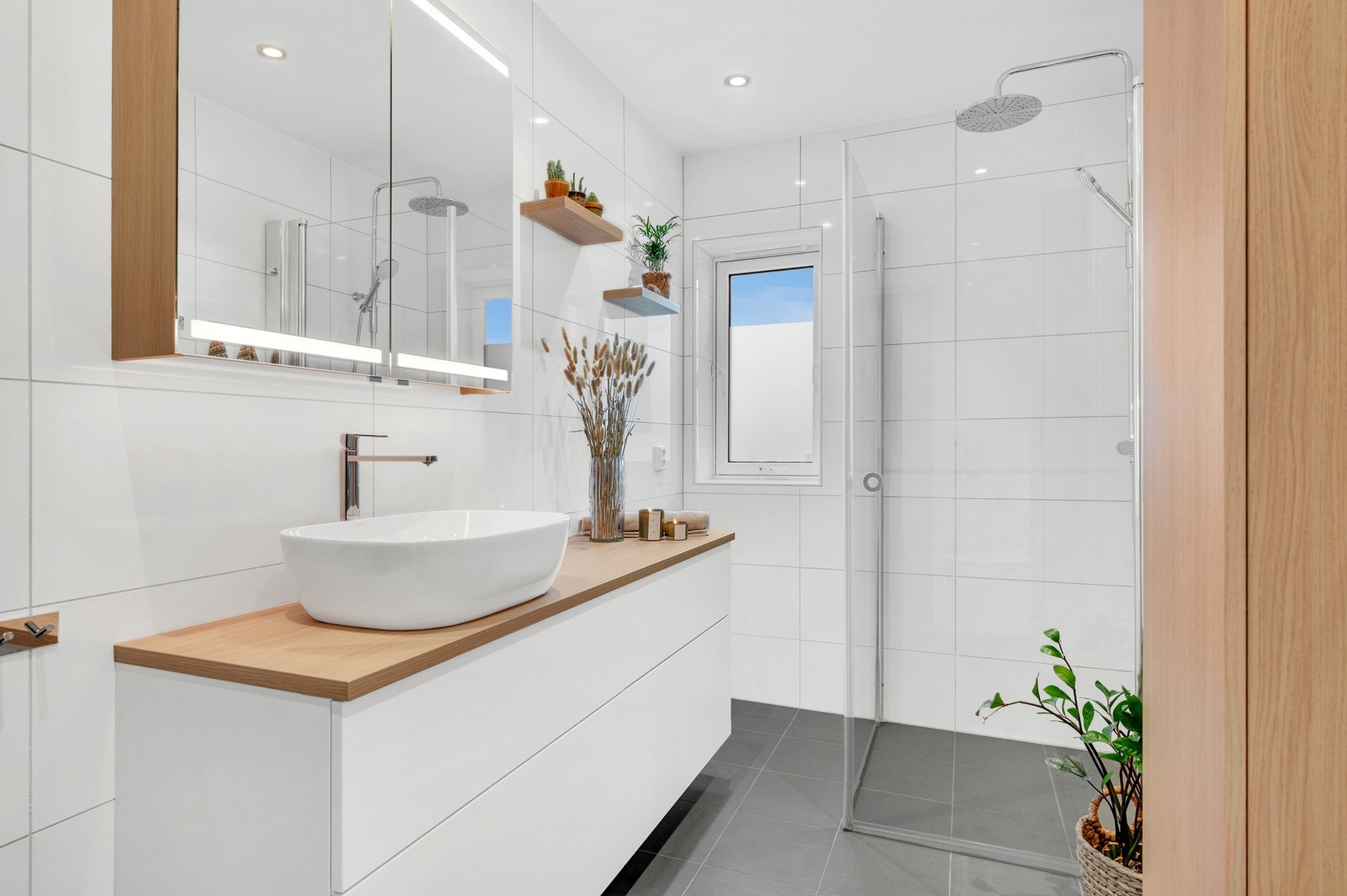 Badet ble pusset opp i 2020 av fagfolk. Varmekabler i gulvet, downlights i himling. Av innredning er det dusjhjørne, veggmontert WC, kran og avløp til vaskemaskin og servant med skuffer- og overskap. Galleribilde
