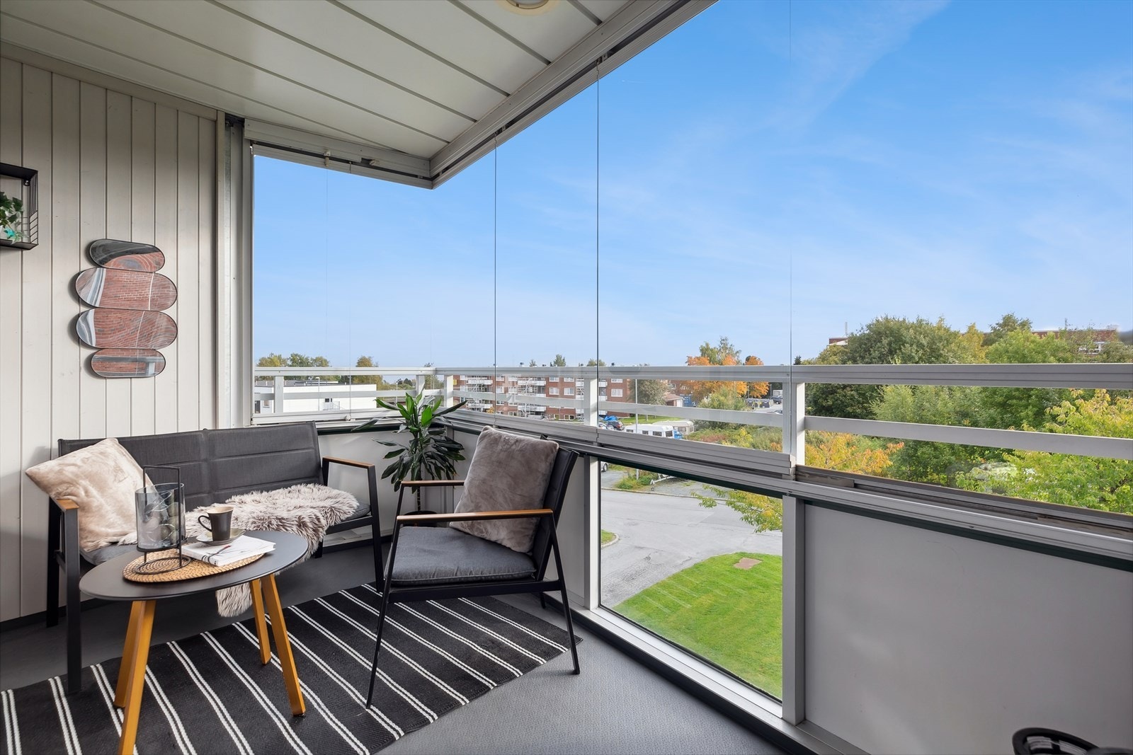 Utenfor stuen ligger en innglasset balkong med vid, frodig utsikt. Galleribilde
