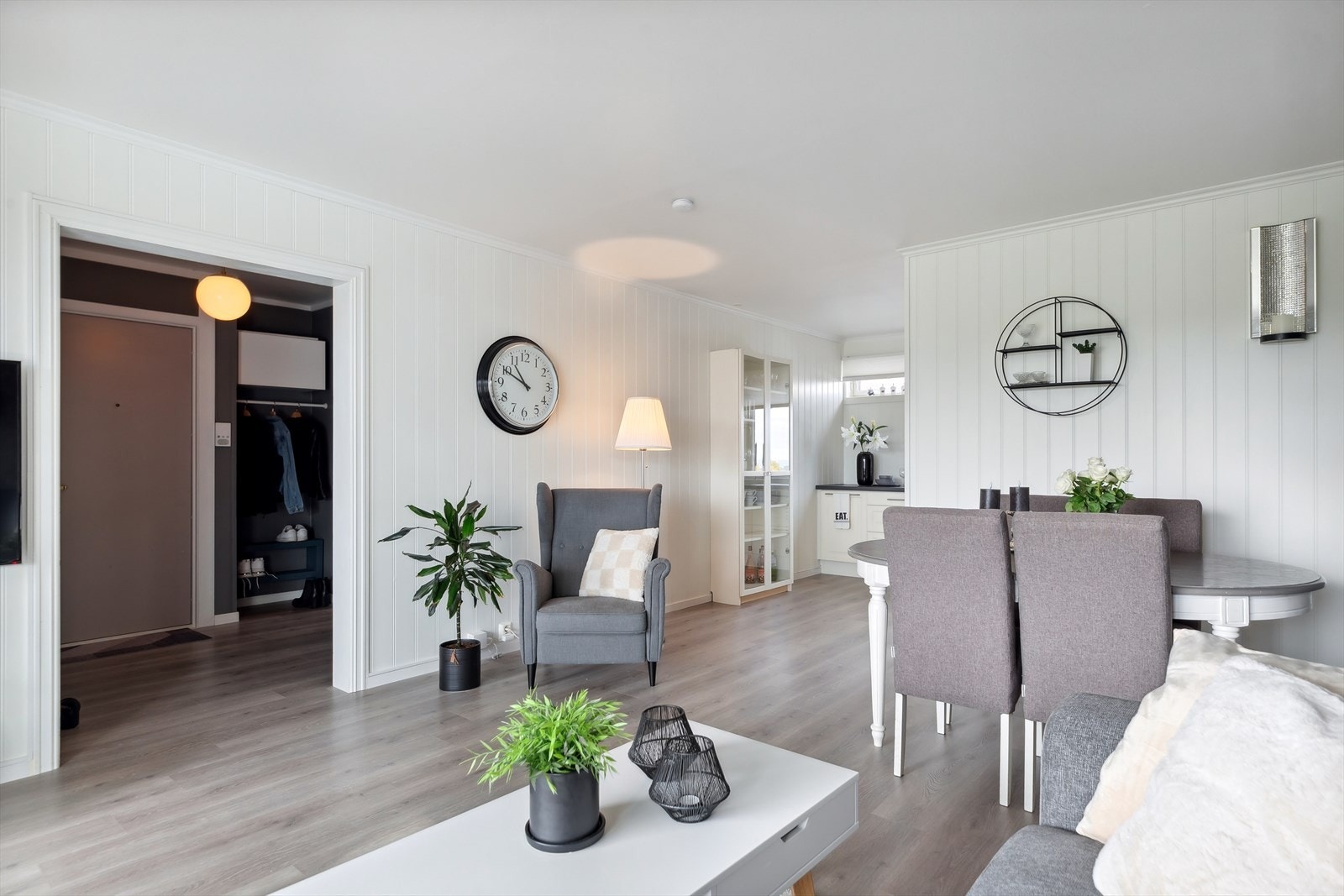 Stuen er et flott rom med en kombinasjon av laminatgulv, hvitmalt veggpanel og stilig kontrastvegg. Galleribilde