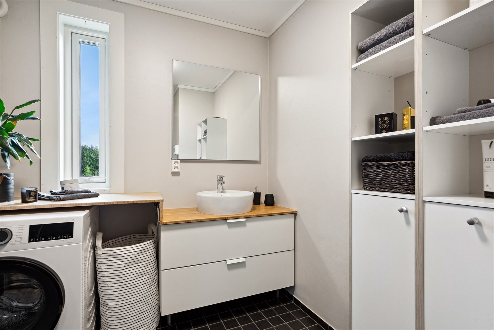 Badet har dusjhjørne, opplegg for vaskemaskin og god oppbevaringsplass i romslig innredning. Galleribilde
