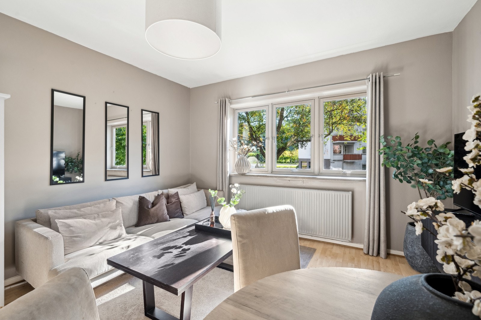 Det er god plass til både sofa og spisebord i stuen Galleribilde