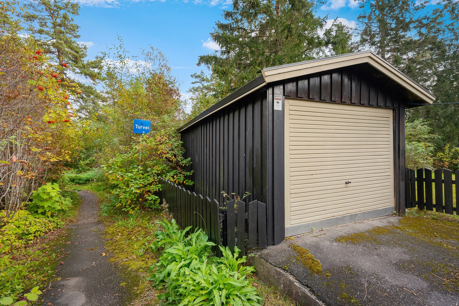 Frittstående enkelgarasje med biloppstillingsplasser foran denne Galleribilde