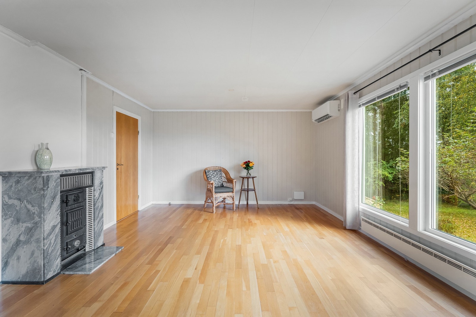 Stue har vakker peisovn i stuen og luft til luft varmepumpe Galleribilde