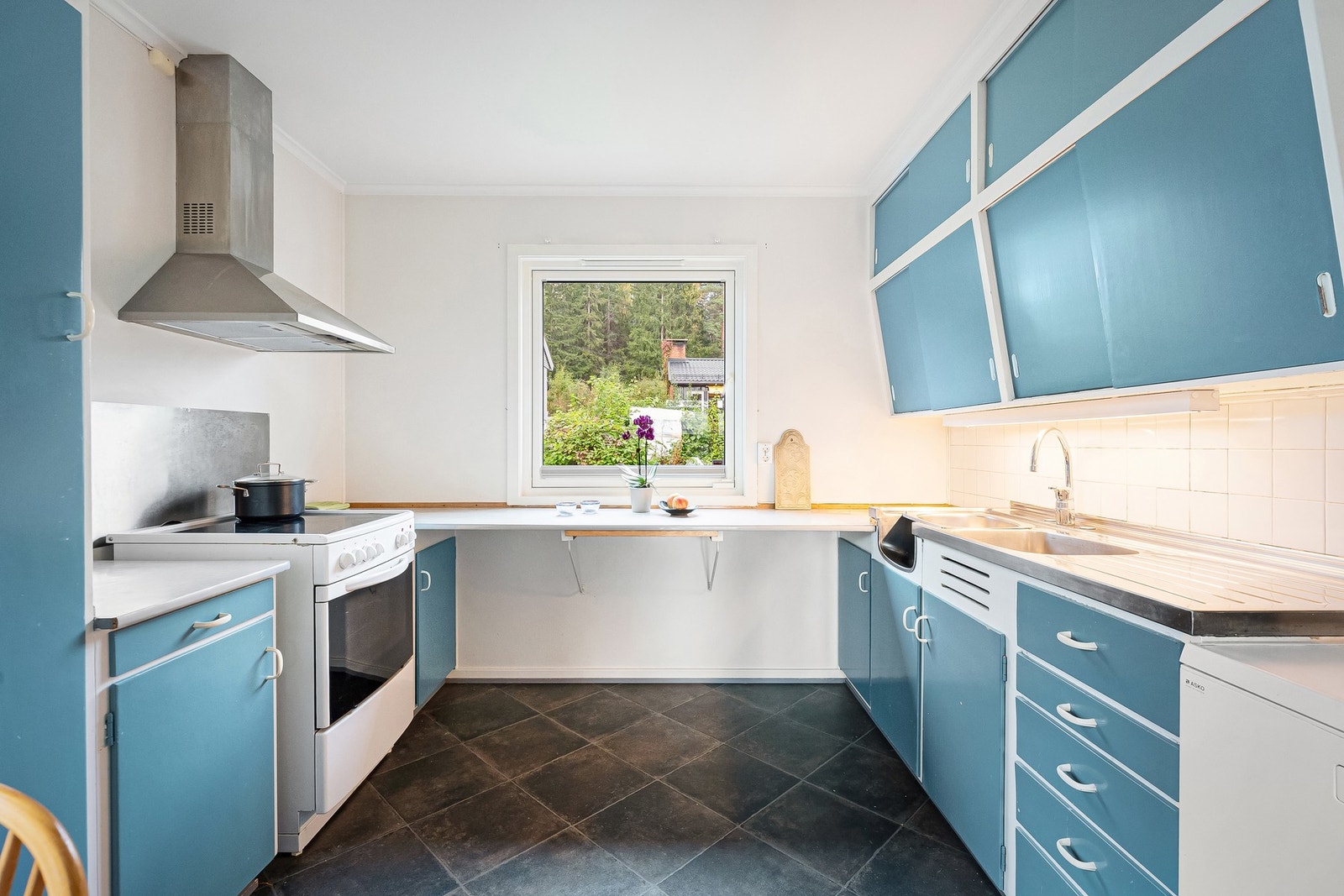 Eldre kjøkken med malte flater og enkel innredning Galleribilde