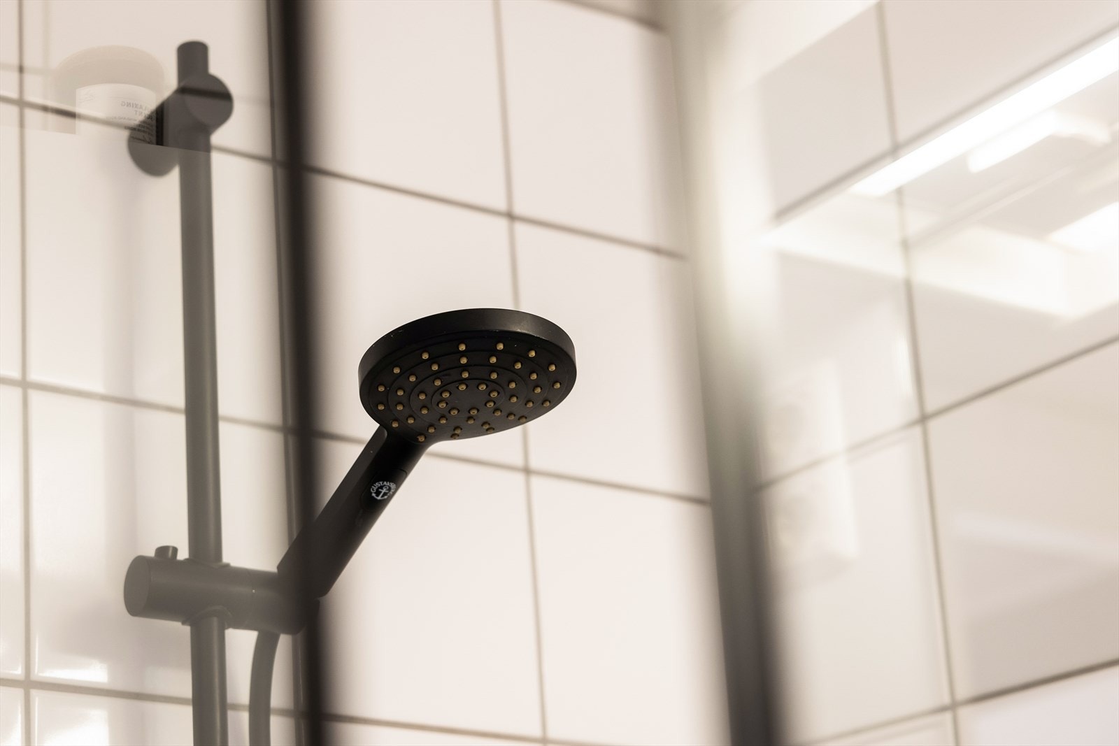 Innredning med vegghengt klosett, servantinnredning, servant med ettgreps blandebatteri, dusjdører, dusjarmatur, opplegg og plass til vaskemaskin. Galleribilde