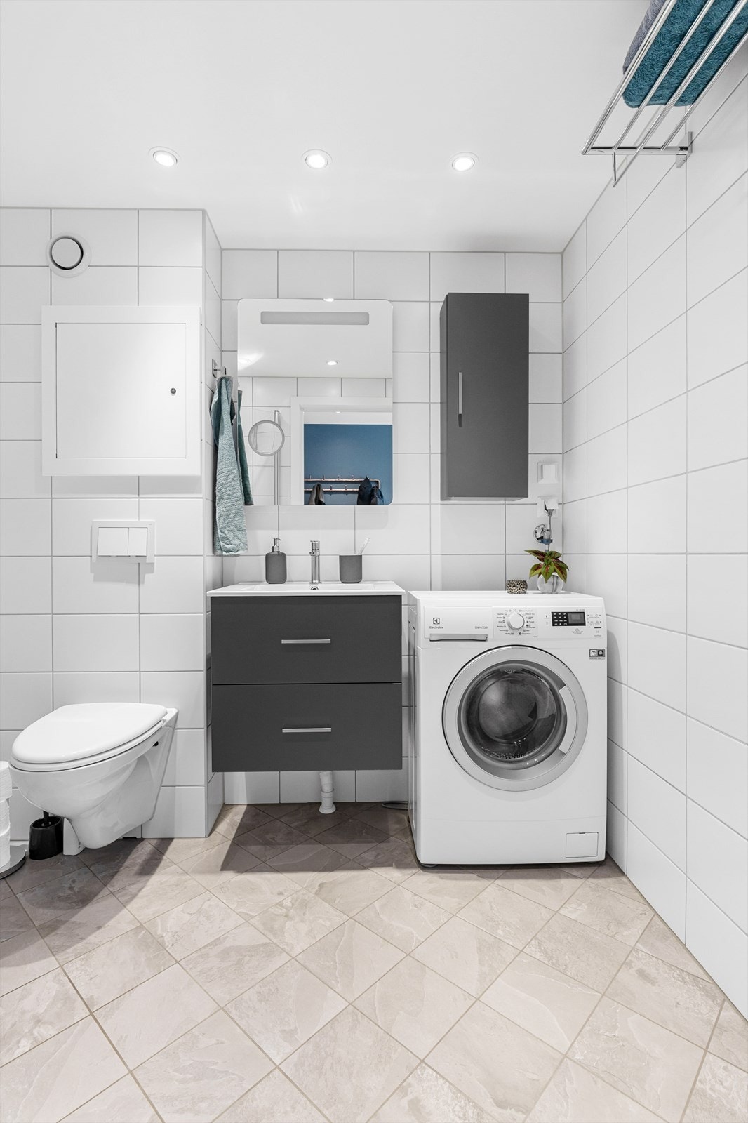 Badet er innredet med vegghengt toalett, vegghengt servantskap med servant, speil med belysning, vegghengt skap for oppbevaring og det er opplegg for vaskemaskin. Galleribilde