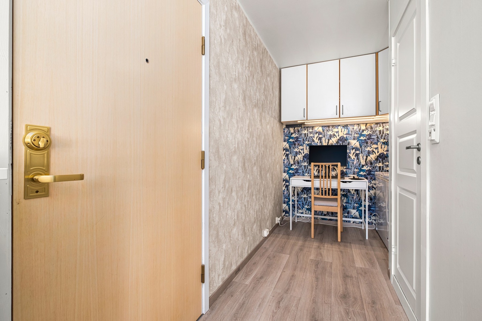 Entreen måler 7 kvm. Her er det svært godt med plass til å etablere stor garderobe dersom det er ønskelig. Hjørnet er benyttet til hjemmekontor av dagens eier. Galleribilde