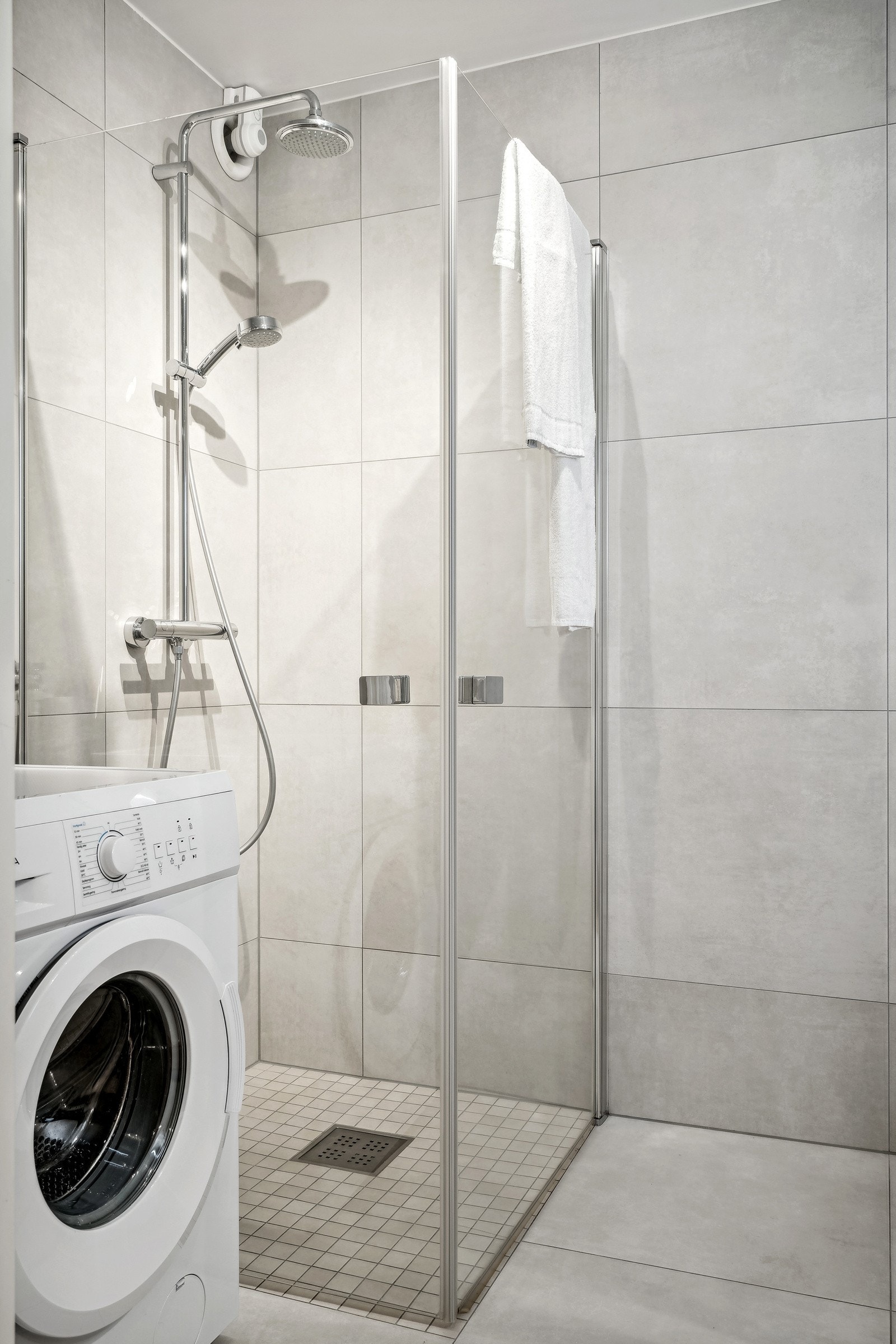 Opplegg for vaskemaskin og dusjhjørne med takdusj innfellbare glassdører. Galleribilde