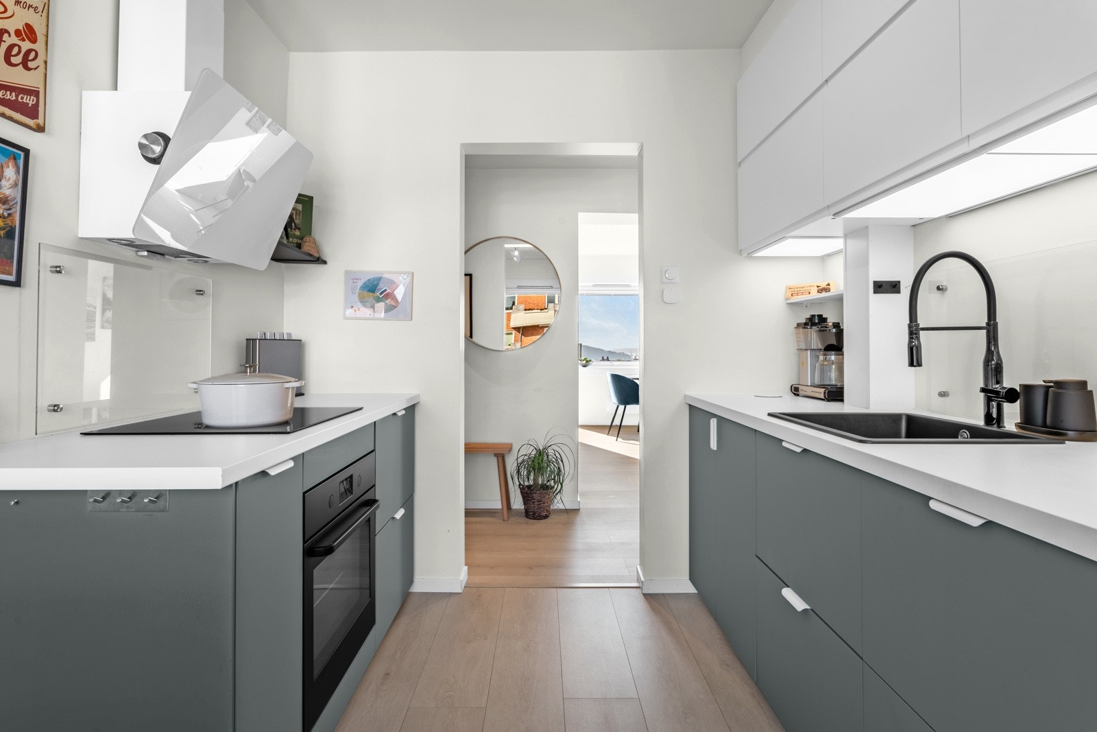 Kjøkkeninnredning med grønne glatte fronter og laminert benkeplate. Galleribilde