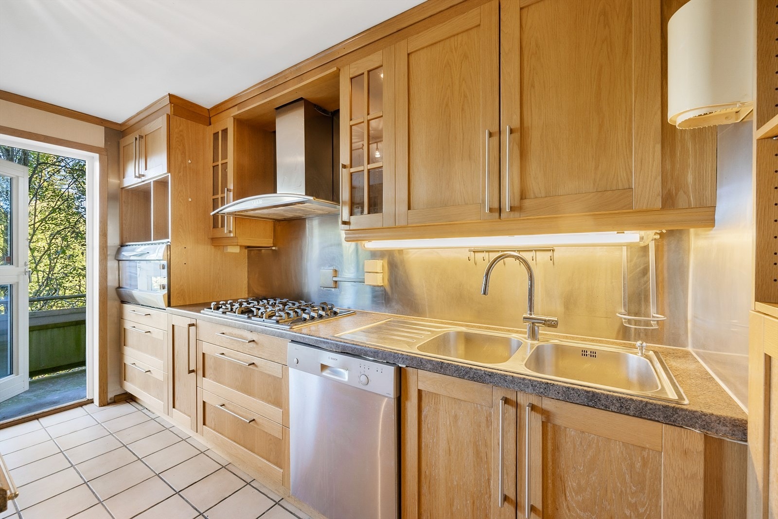 Kjøkkeninnredning med eik fyllingsfronter, laminat benkeplate og flere fronter med glassfelt Galleribilde