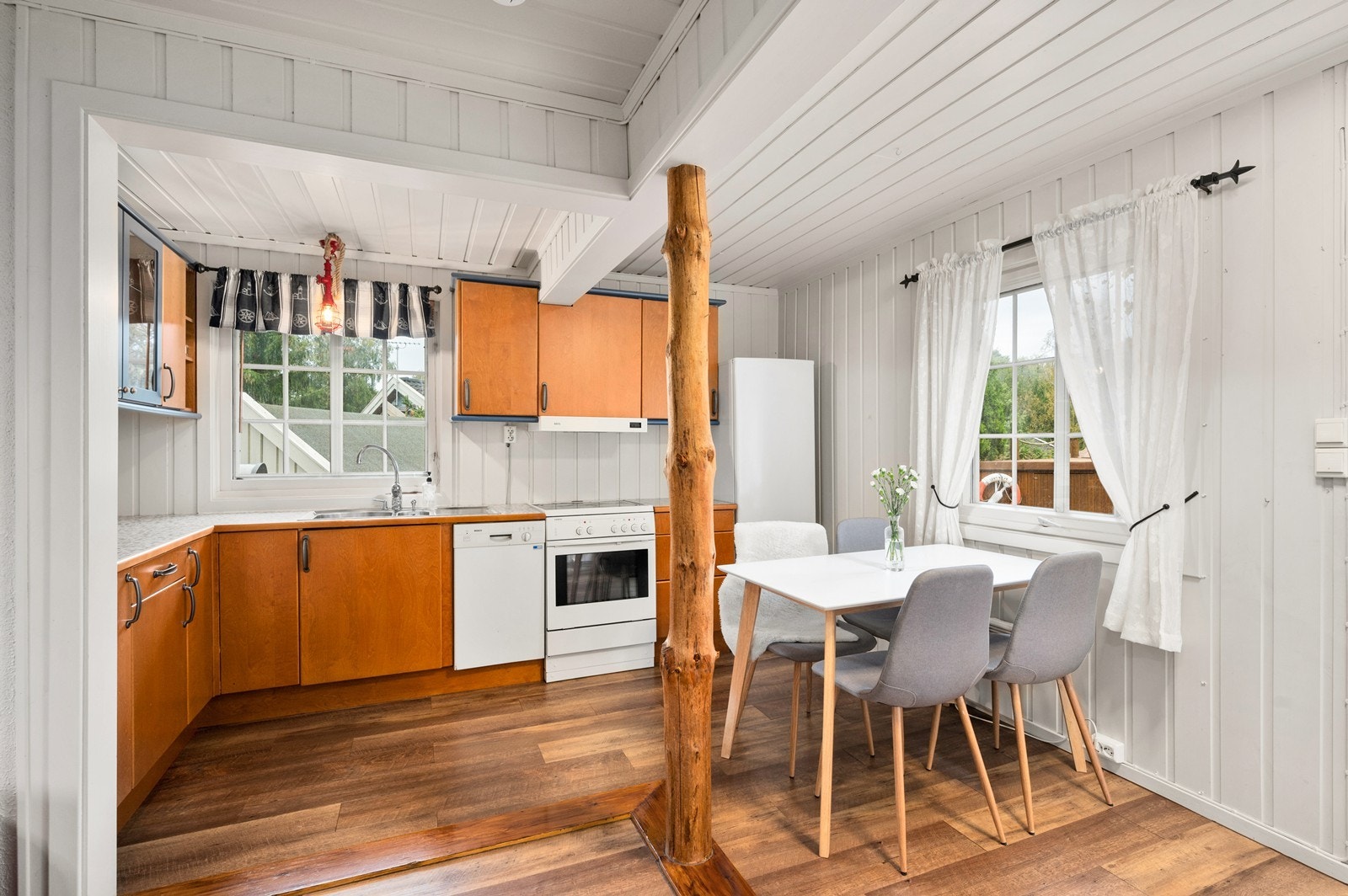 Kjøkkenet har innredning med glatte fronter og laminat benkeplate Galleribilde