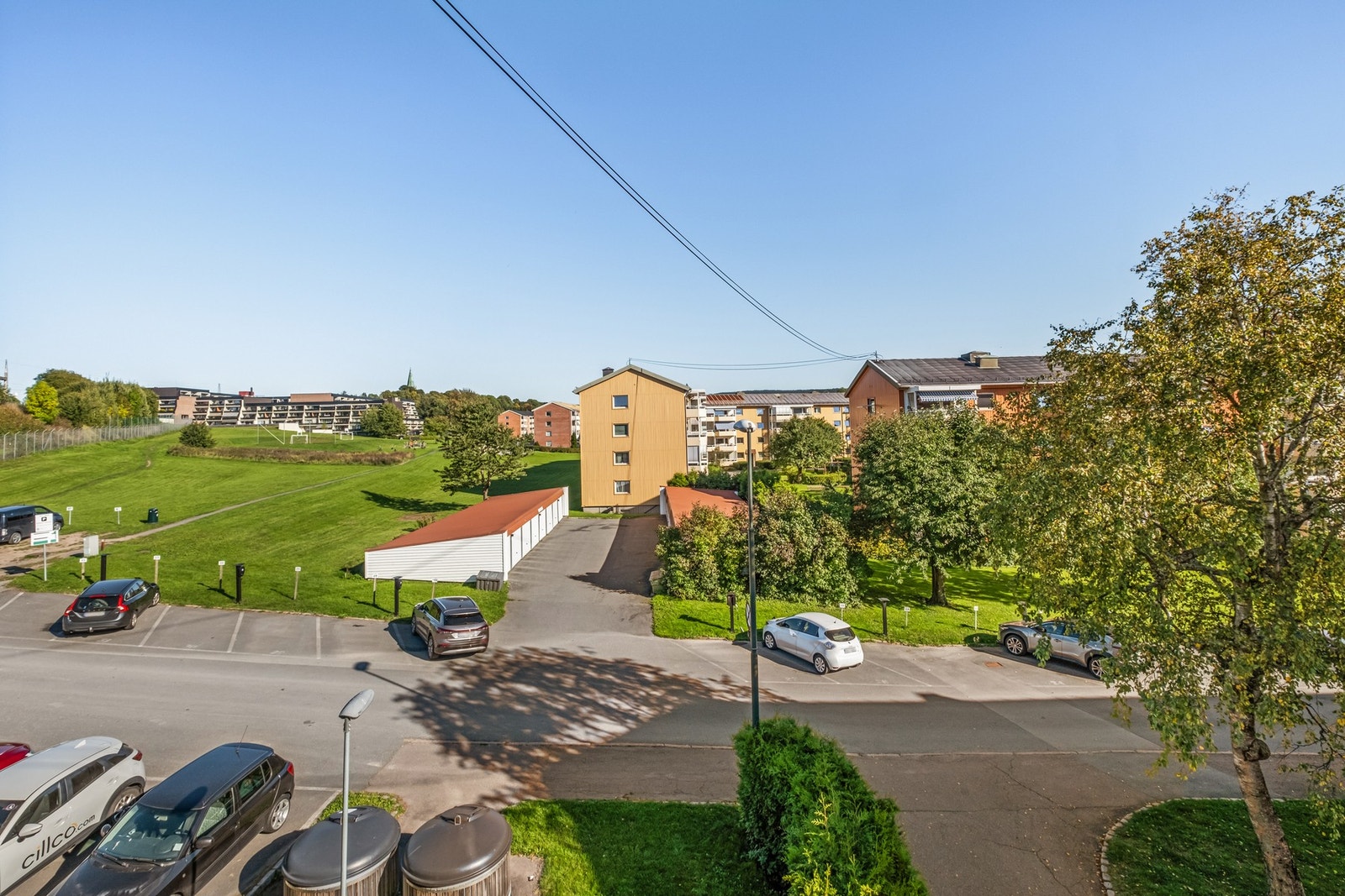 Utsikt fra hjørnevindu i stuen. Det er gateparkering og parkeringsleie via borettslaget.
Det er stor parkeringsplass øverst til venstre. Galleribilde