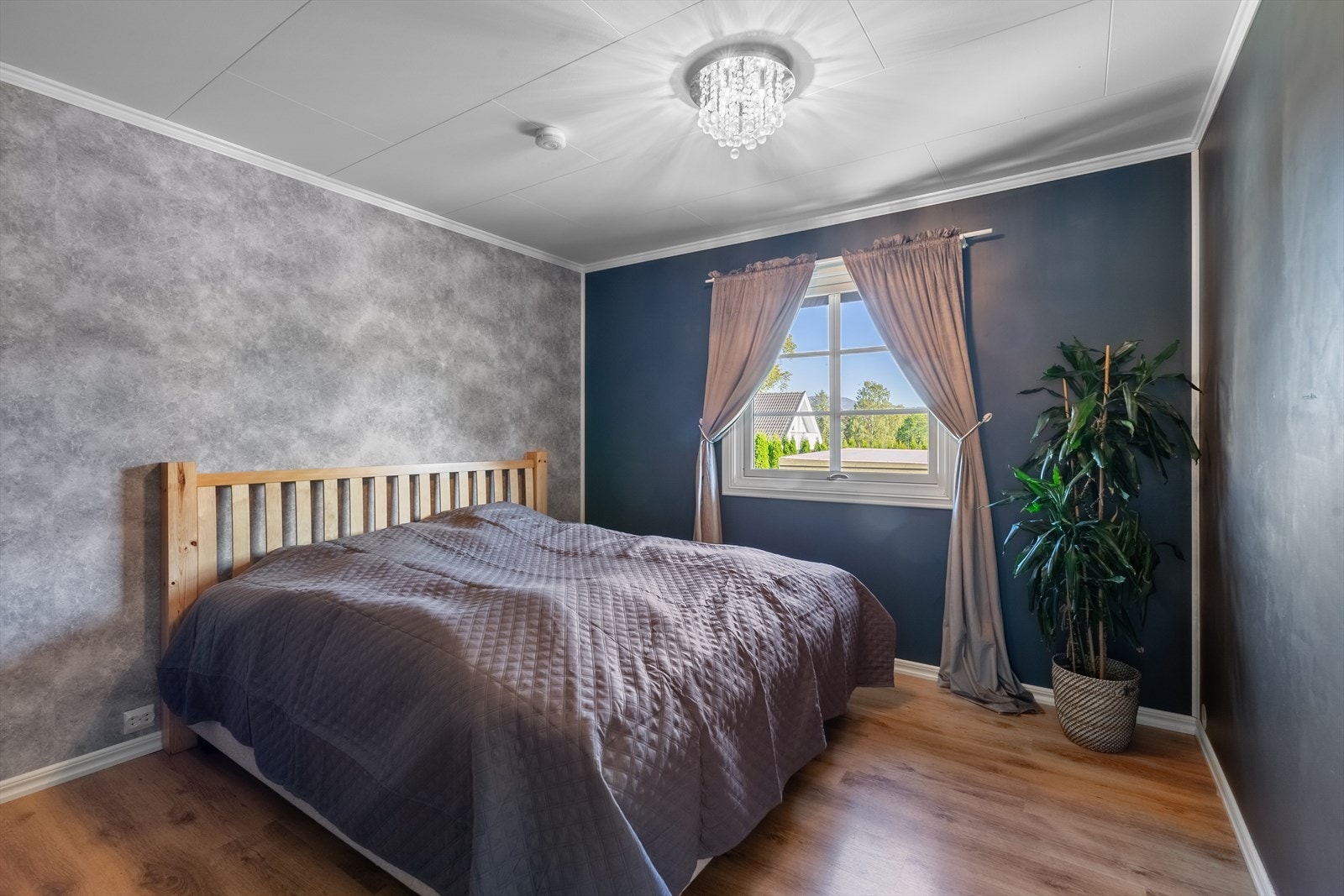 Pent innredet hovedsoverom malt i en behagelig blåtone og har en stilren kontrastvegg med tapet. Galleribilde