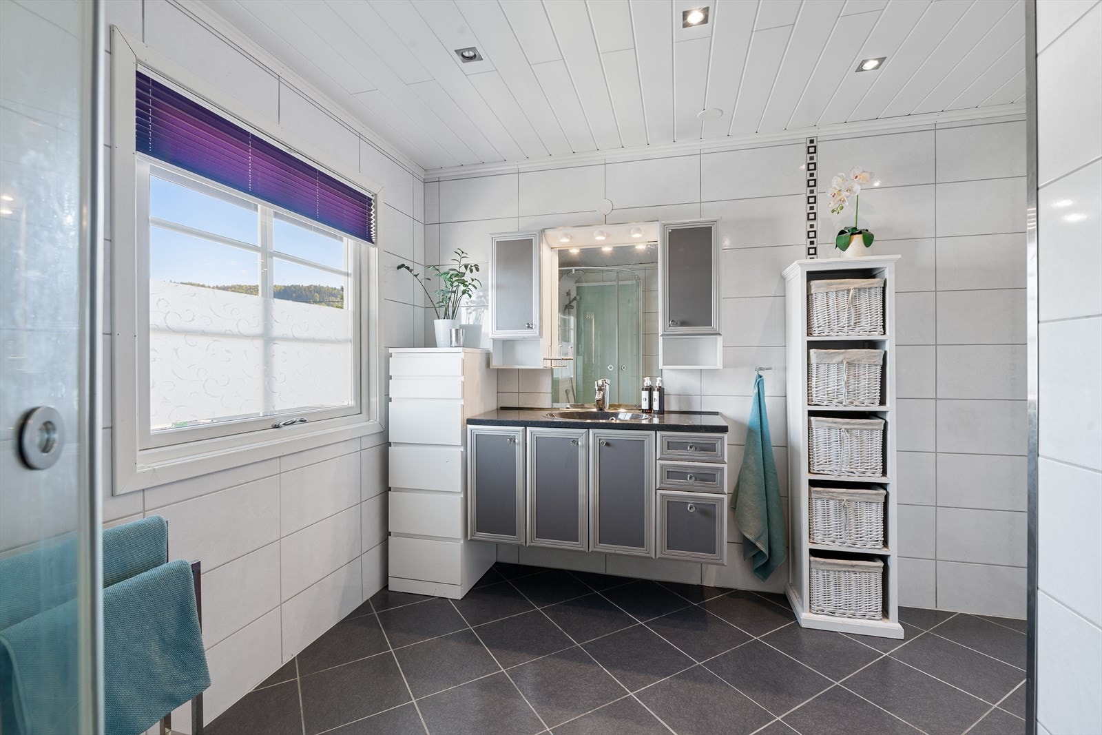 Badet er innredet med en elegant innredning som har rom for oppbevaring i skap. Galleribilde